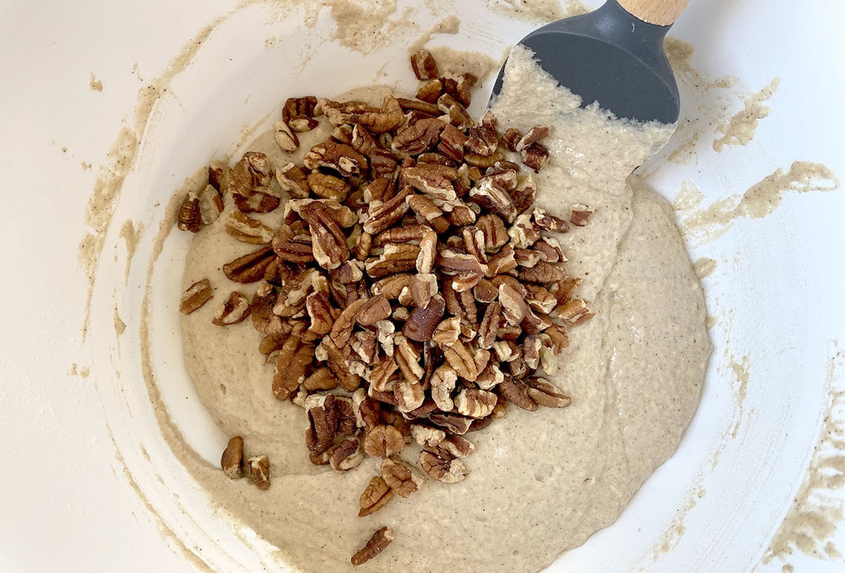 Folding in pecans into Cinnamon Streusel Muffins batter in mixing bowl