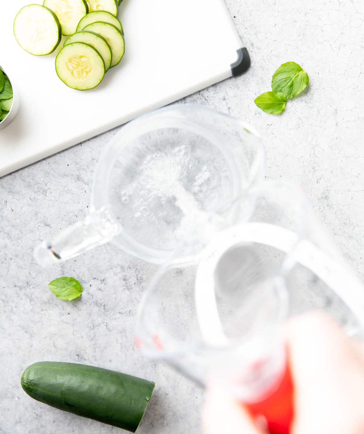 Two photos showing How to Make Cucumber Water – pouring filtered water into a pitcher
