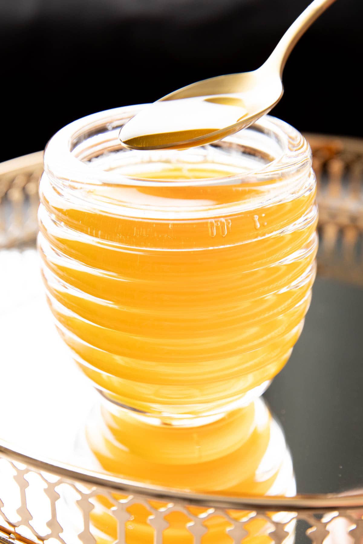 spooning honey syrup out of a jar