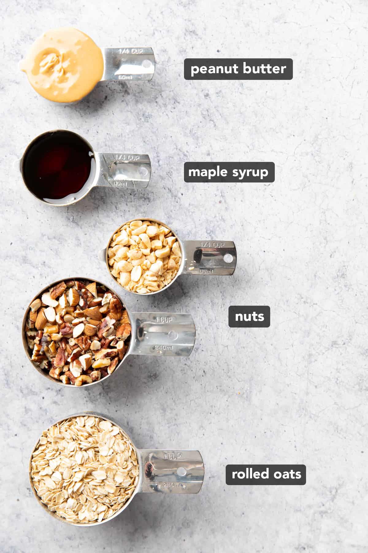 Peanut butter granola ingredients pre-measured in cups on a table
